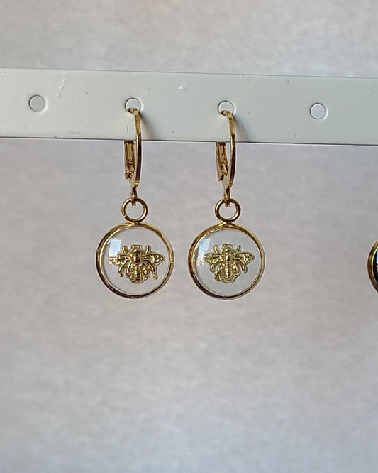 boucles d’oreilles abeille portées sur support, finition dorée, léger et hypoallergénique