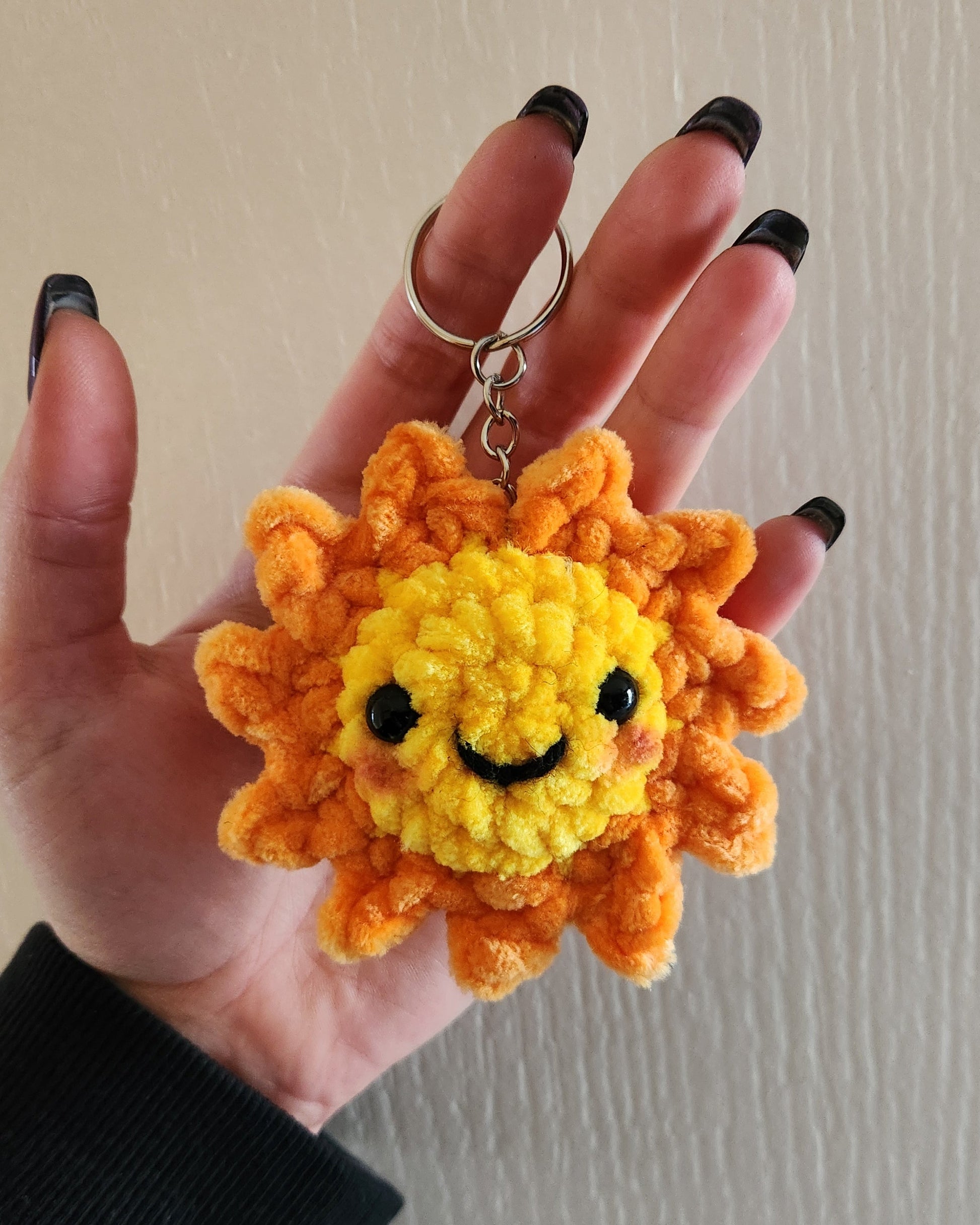 porte clé soleil jaune et orange avec des yeux et une bouche